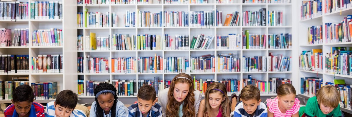 Erwachsene liest Kindern aus einem Buch vor 