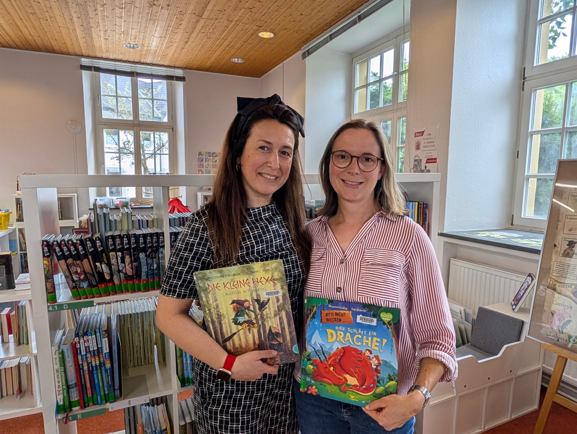 Emine Özcan und Christina von Zons mit Bilderbücher in der Stadtbibliothek Oelde