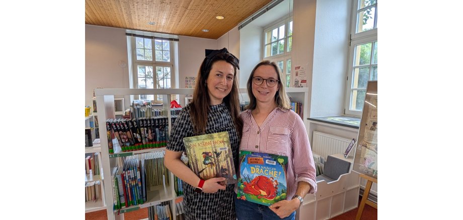Emine Özcan und Christina von Zons mit Bilderbücher in der Stadtbibliothek Oelde