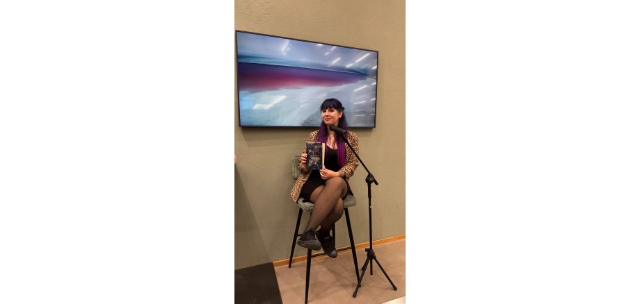 Die Autorin Justine Pust mit ihrem Buch in der Brennerei Schwarze und Schlicht in Oelde.