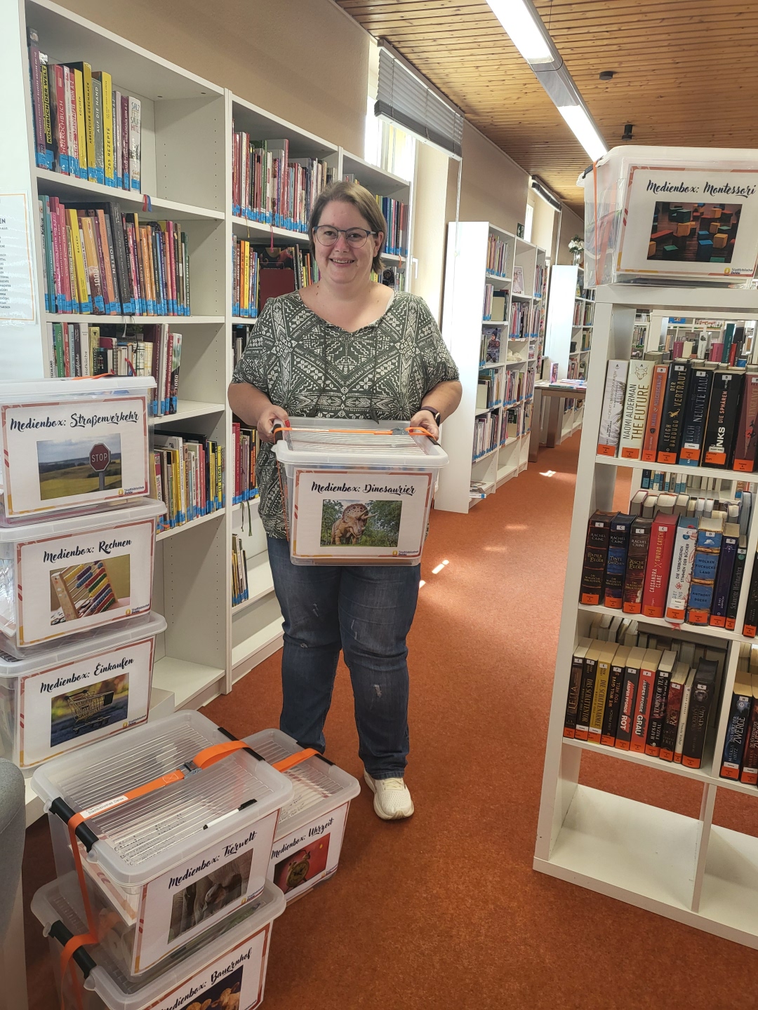 Auszubildende Ute Böse mit den acht Medienboxen der Stadtbibliothek